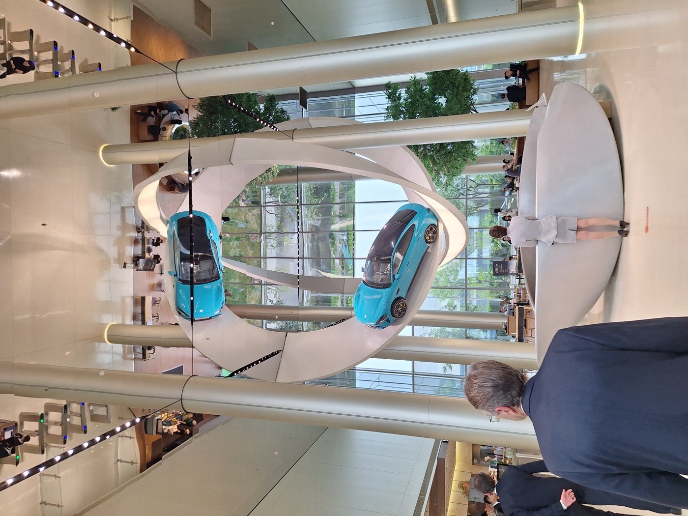 Deux berlines SU7 suspendues dans l'atrium du siège de Xiaomi, à Pékin